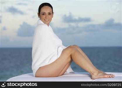 Side profile of a young woman wrapped in a towel