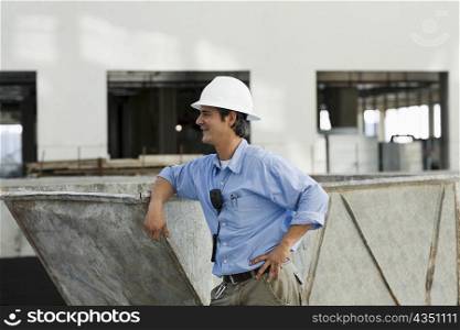 Side profile of an engineer leaning against an industrial equipment