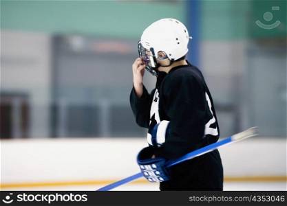 Side profile of an ice hockey player holding an ice hockey stick