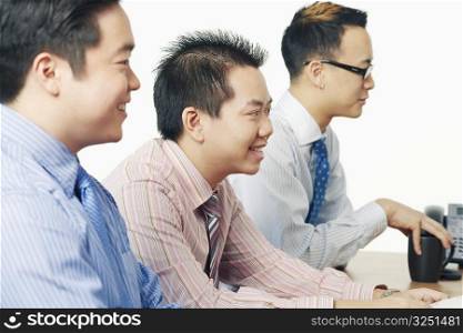 Side profile of three businessmen sitting