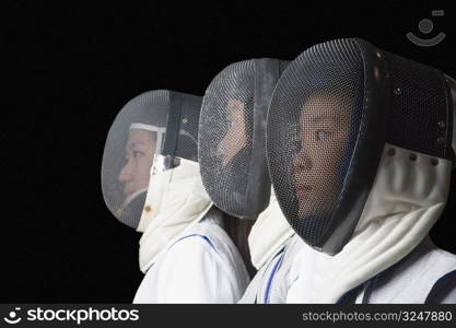 Side profile of three female fencers side by side