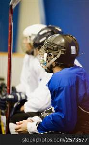 Side profile of three ice hockey players wearing helmets