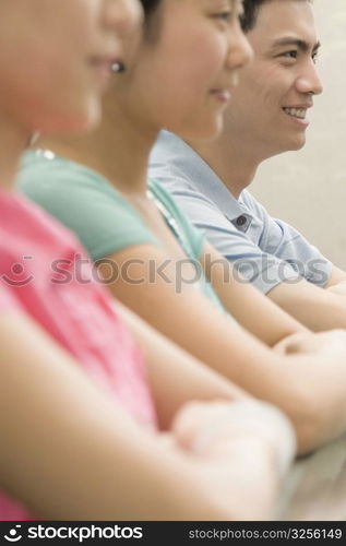 Side profile of three office workers sitting in a conference room