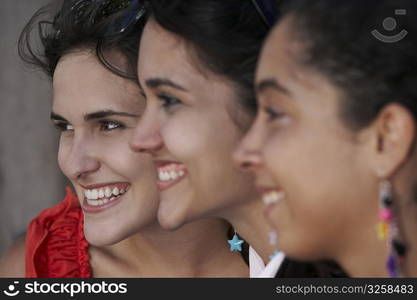 Side profile of three young women smiling