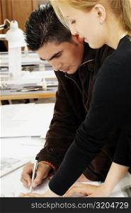 Side profile of two architects working together on a blueprint