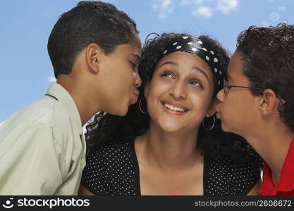 Side profile of two boys kissing a teenage girl