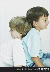 Side profile of two boys sitting back to back