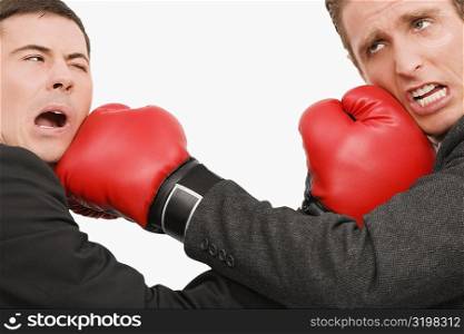 Side profile of two businessmen boxing