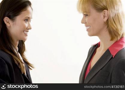 Side profile of two businesswomen smiling