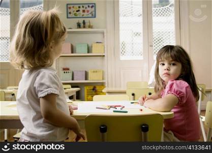 Side profile of two girls in a classroom