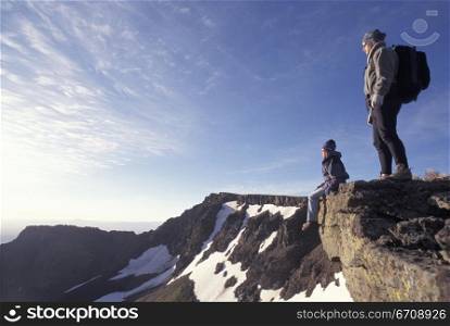 Side profile of two people on the hill