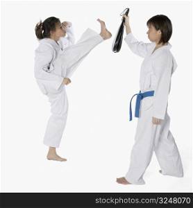 Side profile of two young women practicing karate