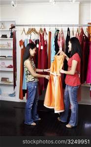 Side profile of two young women standing in a clothing store