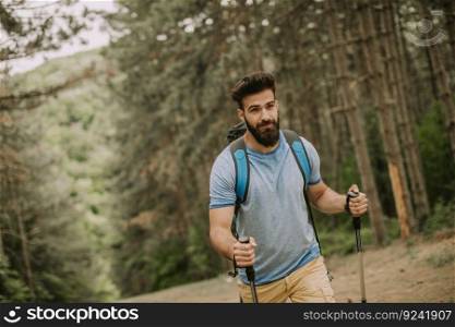 Side view at young handsome bearded hiker in mountain