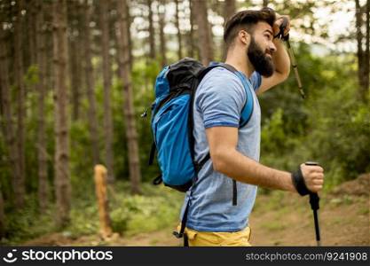 Side view at young handsome bearded hiker in mountain