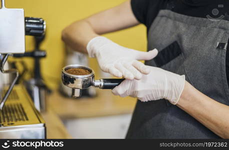 side view barista with latex gloves preparing coffee machine. High resolution photo. side view barista with latex gloves preparing coffee machine. High quality photo