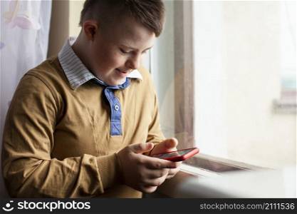 side view boy with down syndrome holding smartphone