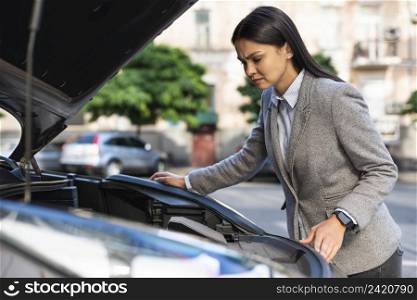 side view businesswoman checking car s motor with hood up