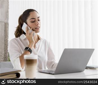 side view businesswoman working with smartphone laptop