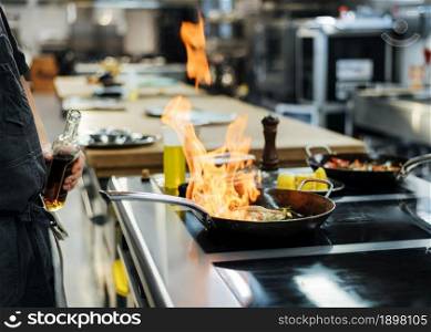 side view chef flambeing dish kitchen. Resolution and high quality beautiful photo. side view chef flambeing dish kitchen. High quality beautiful photo concept