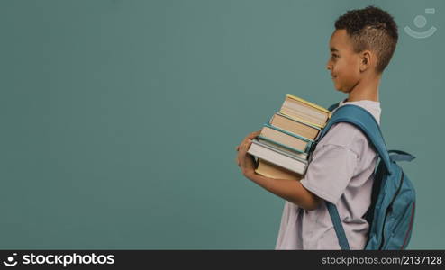 side view child holding pile books