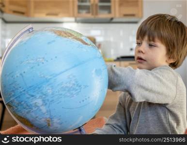 side view child looking earth globe