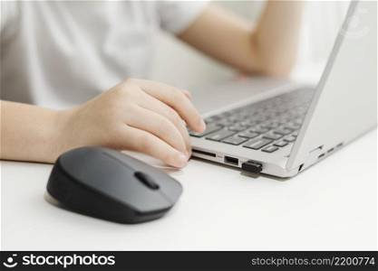 side view child using laptop mouse