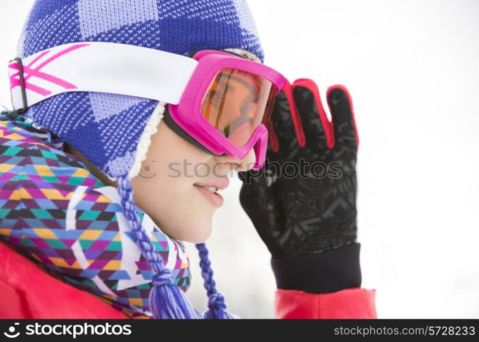 Side view close-up of beautiful young woman in ski goggles looking away