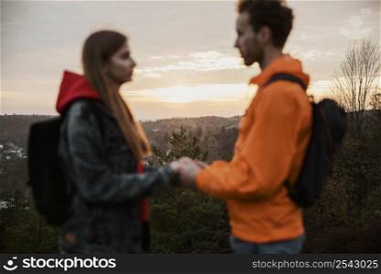 side view couple holding hands sunset road trip