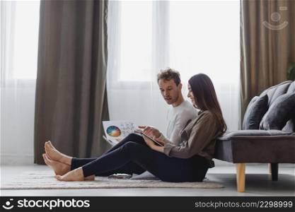 side view couple planning redecorate house while sitting floor