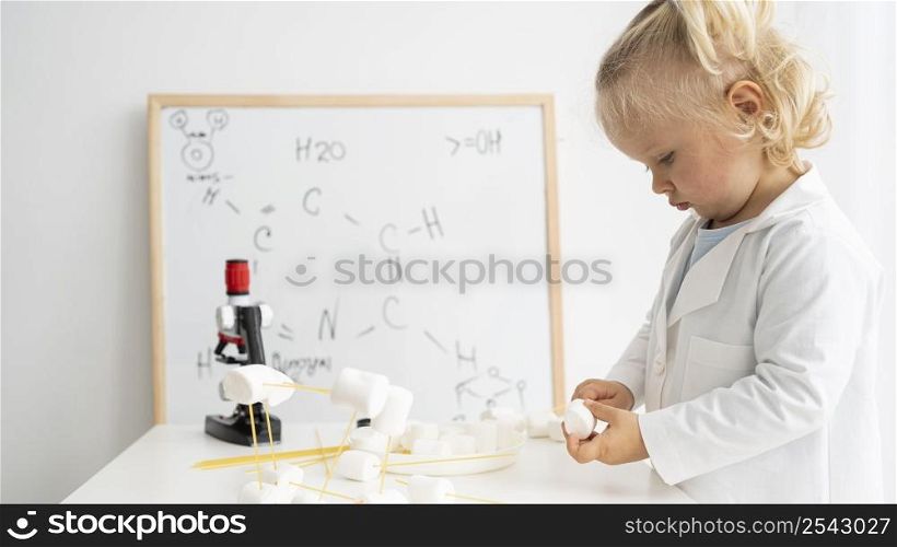 side view cute toddler learning about science with whiteboard microscope