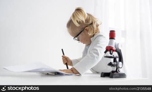 side view cute toddler with lab coat microscope