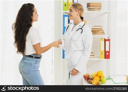 side view doctor patient shaking hands