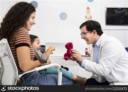 side view doctor playing with baby boy