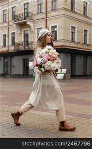 side view elegant woman outdoors holding bouquet flowers spring