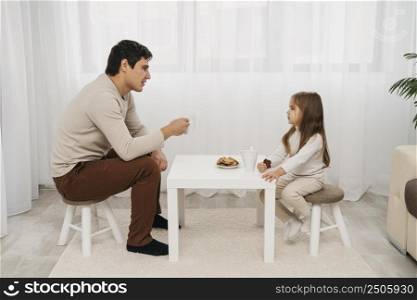 side view father daughter eating together home