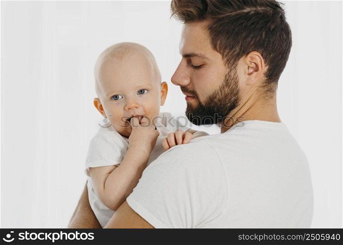 side view father holding his baby