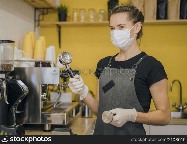 side view female barista with medical mask preparing coffee machine