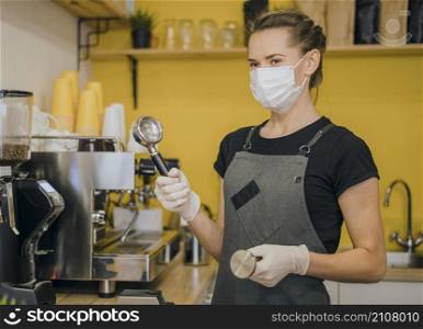 side view female barista with medical mask preparing coffee machine