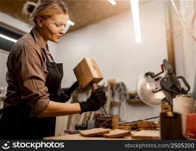 side view female carpenter sculpting wood studio