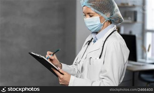 side view female doctor with medical mask hairnet holding clipboard