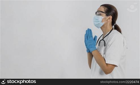 side view female doctor with medical mask praying with copy space