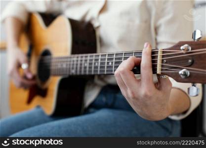 side view female musician playing acoustic guitar