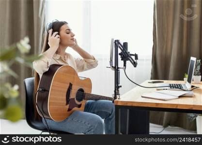 side view female musician playing acoustic guitar preparing record song home