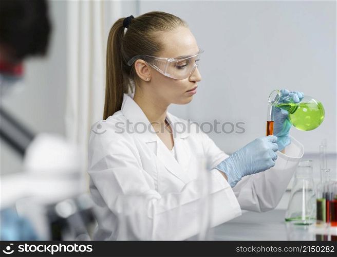 side view female researcher laboratory with test tubes safety glasses