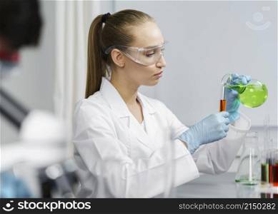 side view female researcher laboratory with test tubes safety glasses