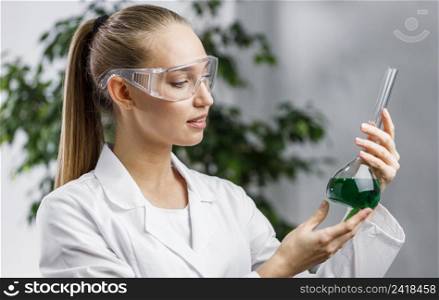 side view female researcher with test tube safety glasses