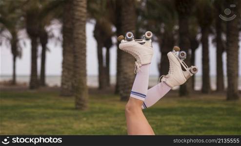 side view female s leg wearing white roller skate against tree