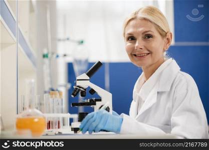 side view female scientist posing lab with microscope surgical gloves