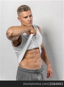 side view fit man showing abs through tank top